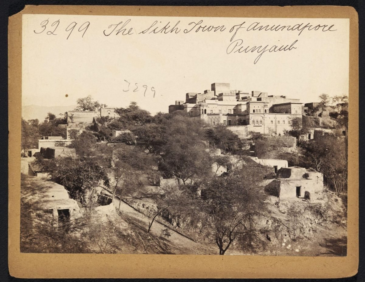 An old sepia photograph of a walled hill town