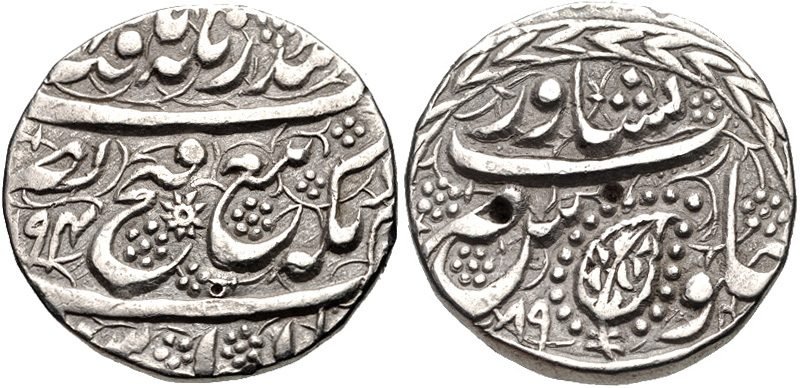Both faces of a worn silver coin with Persian script