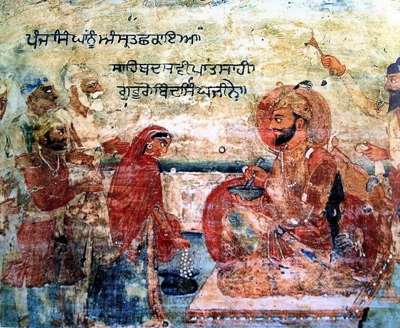 A wall painting of the Guru stirring a bowl with a sword before five men