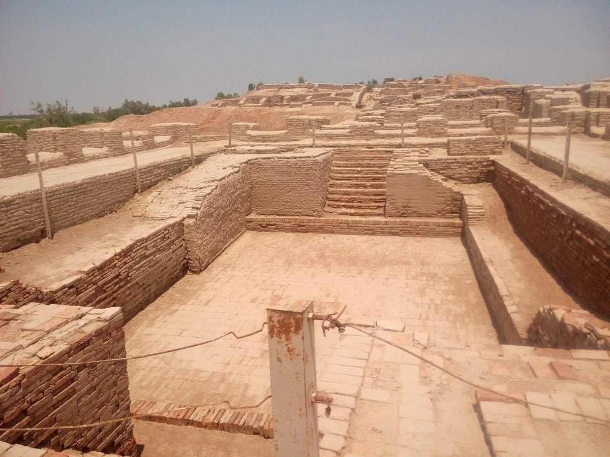 A large rectangular brick-lined tank with steps, surrounded by brick walls, under a clear sky