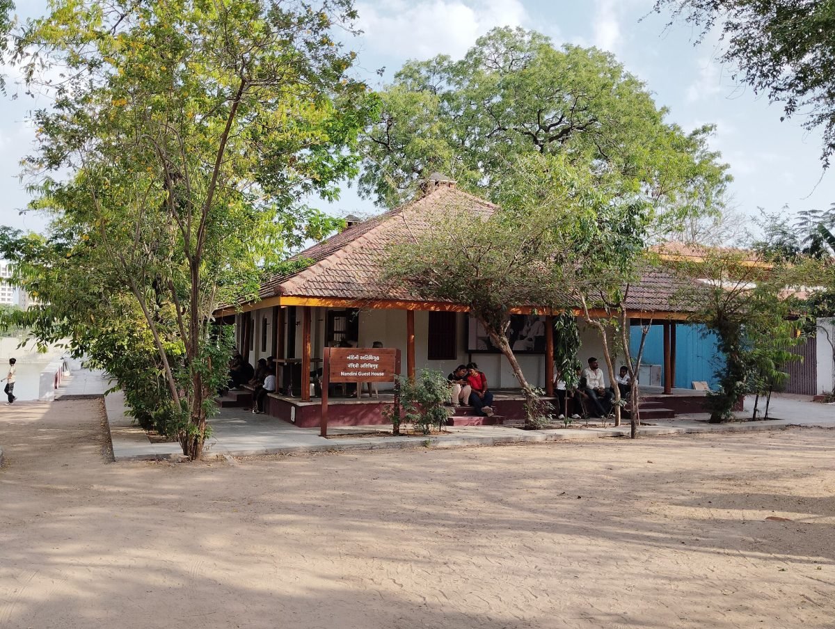 A low tiled-roof house with a veranda among trees at the Sabarmati Ashram in Ahmedabad