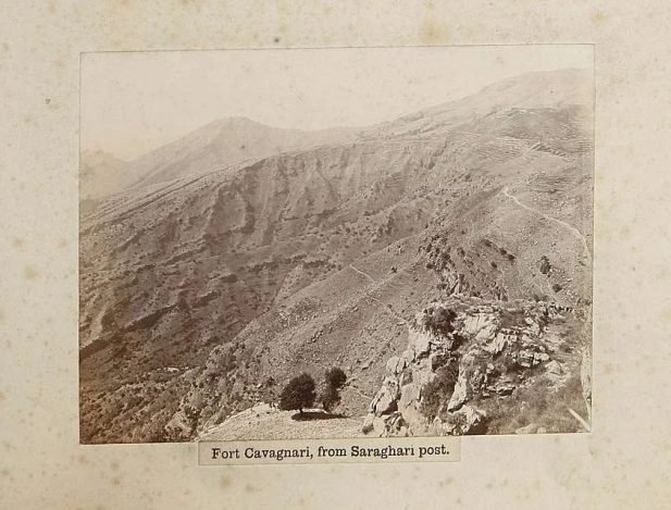An old black-and-white photograph looking along a bare ridge towards a distant fort